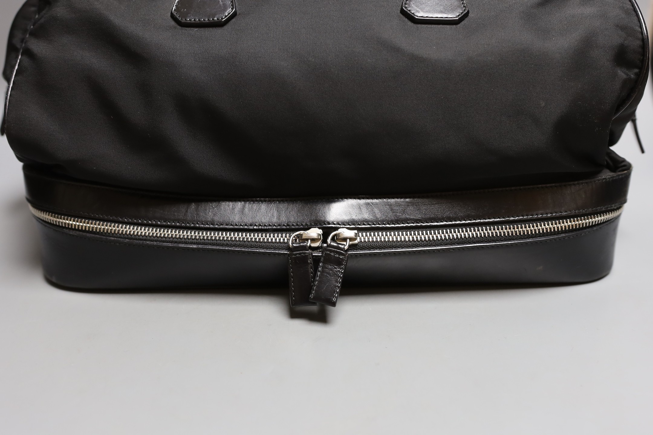 A Prada bowling bag style with zip up compartment
